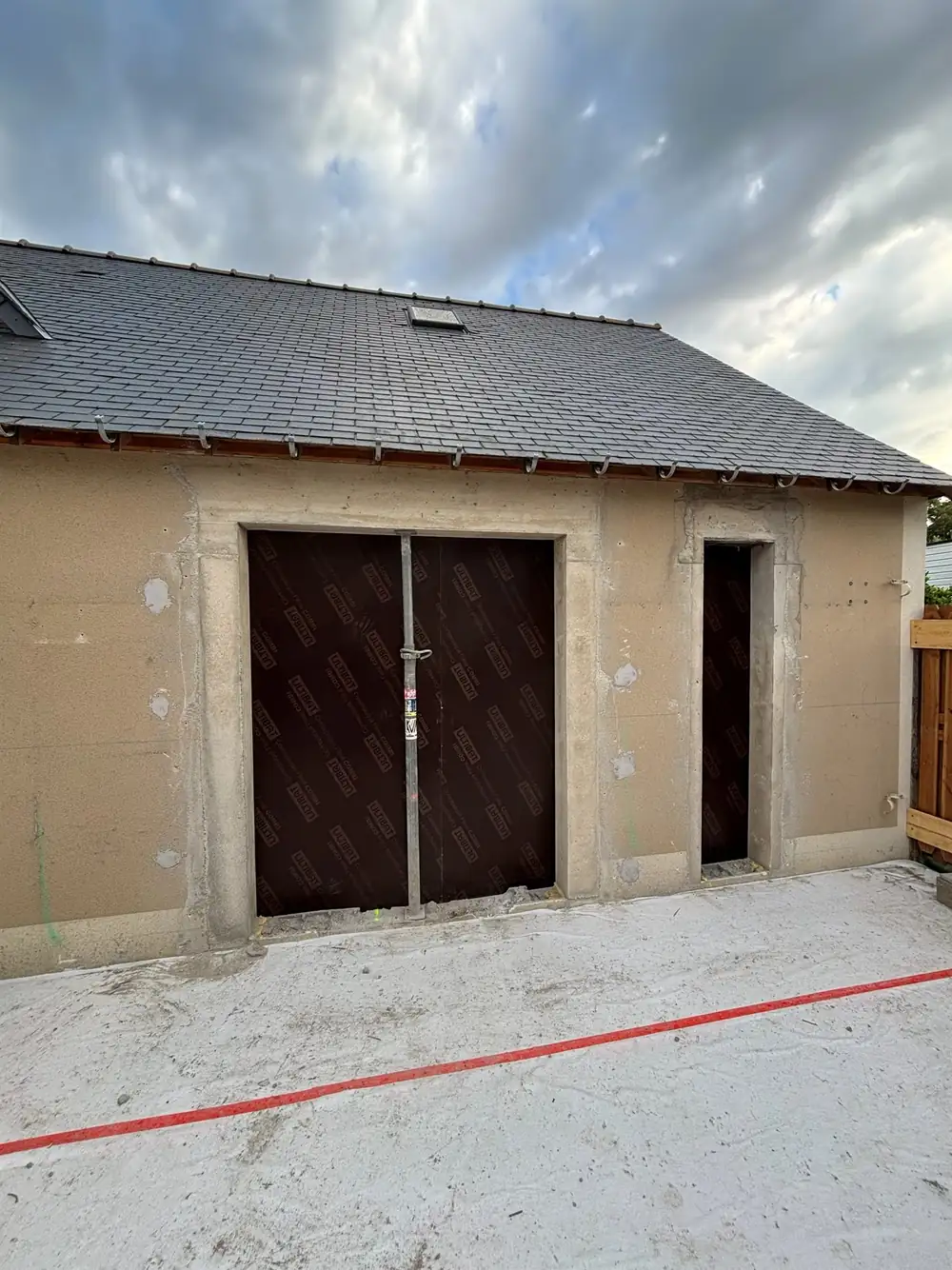 Rénovation extérieure d'un bâtiment en pierre par KVM Construction — toiture neuve et façade enduite