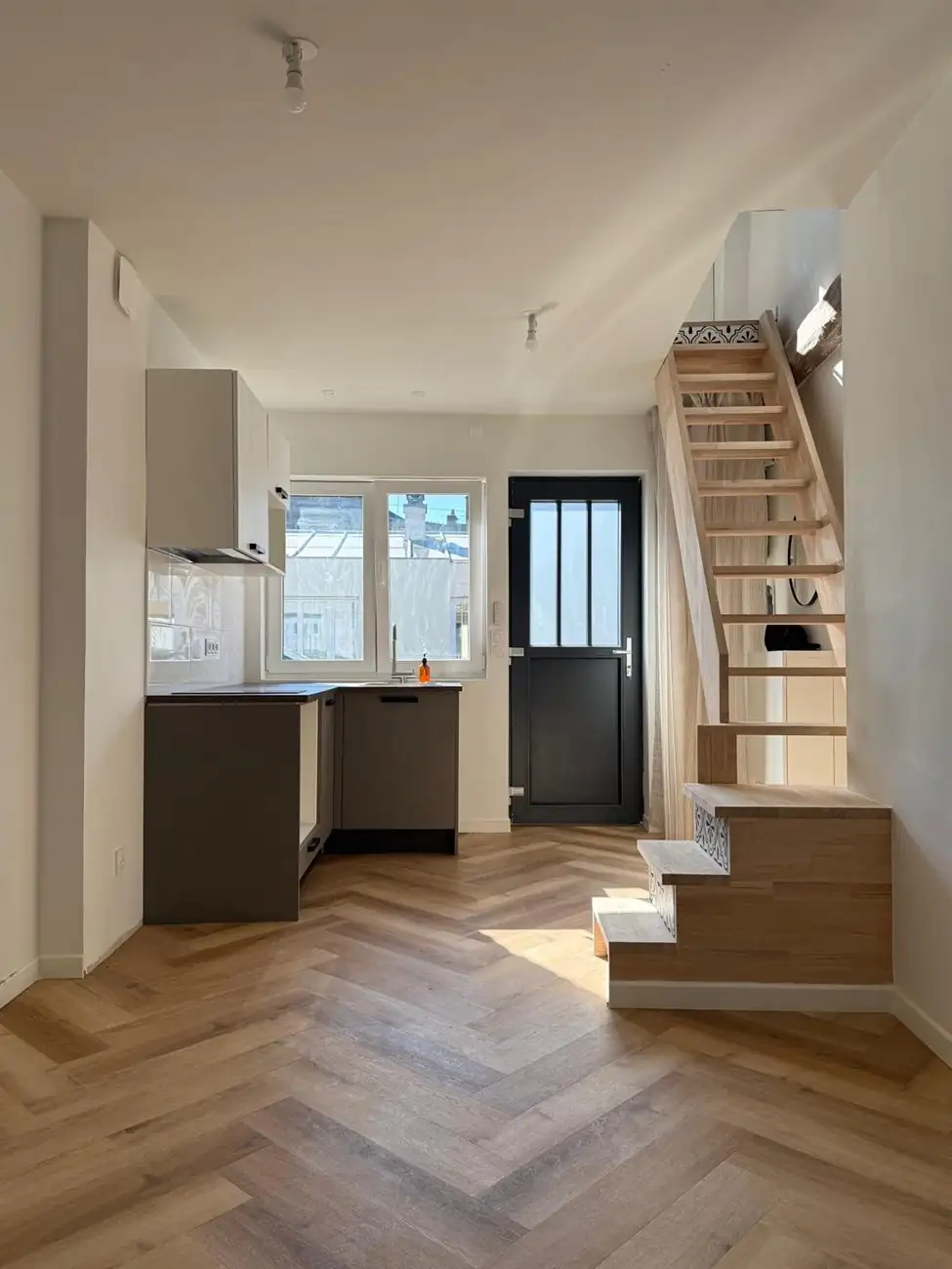 Pièce de vie avec escalier bois et parquet chevron, rénovation Nozay